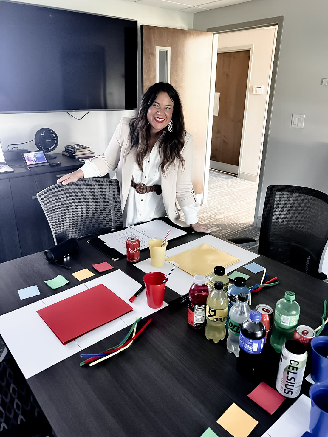 A boardroom table laid out for a Triad workshop with colour cards, notebooks and drinks